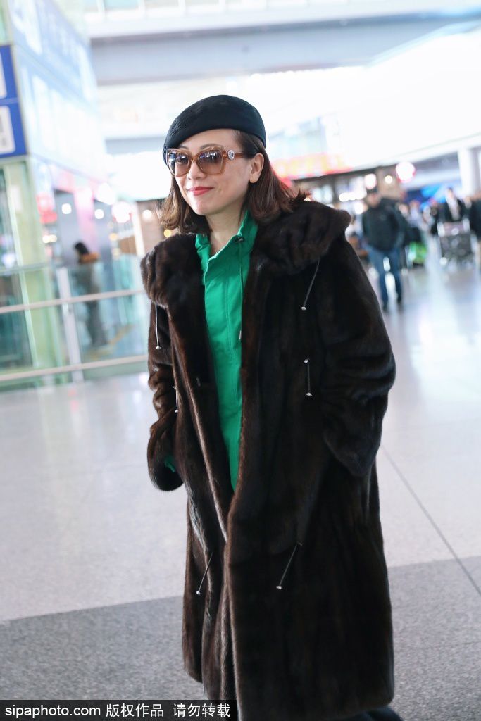 邓萃雯穿皮草大衣现身机场 见粉丝跟拍露笑颜